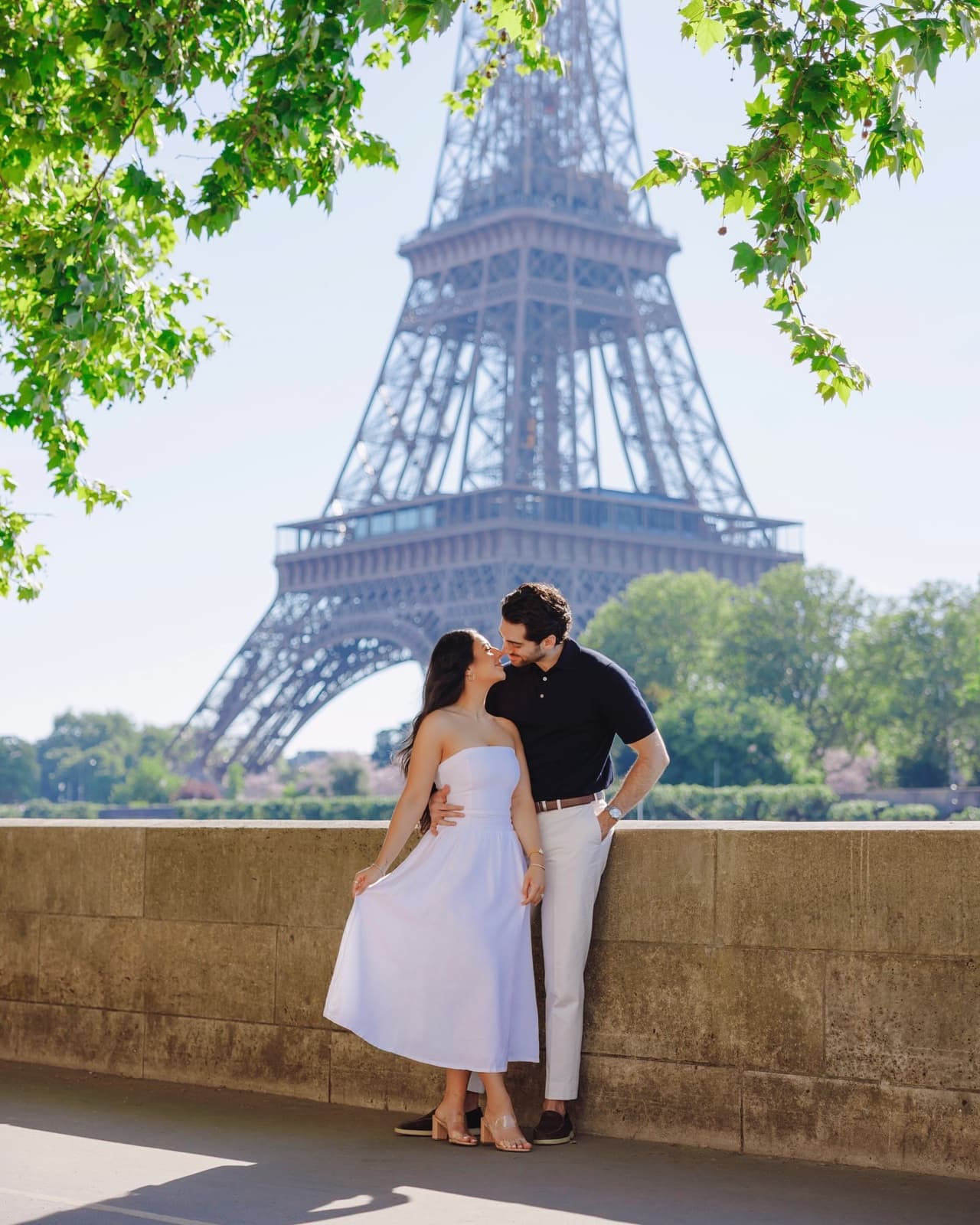 Couple kissing by the Eiffel Tower during a Paris photo session by SabShots